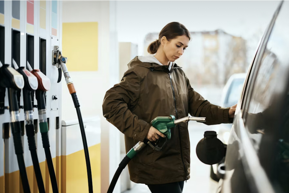 A woman pumps gas into her car